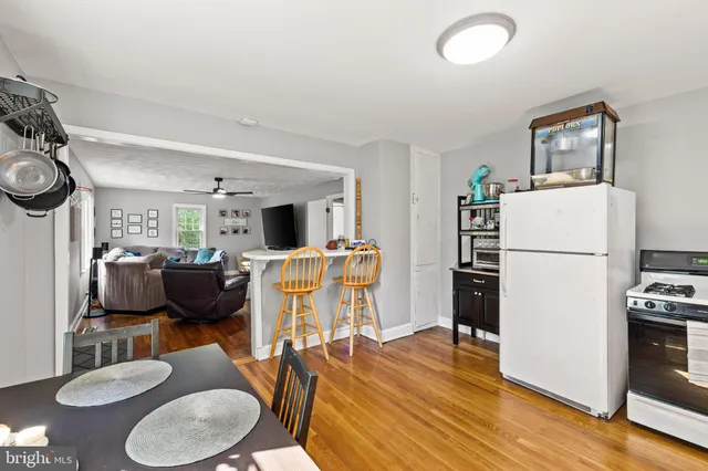 a living room with furniture a refrigerator and a dining table