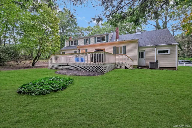 a front view of a house with a yard and trees