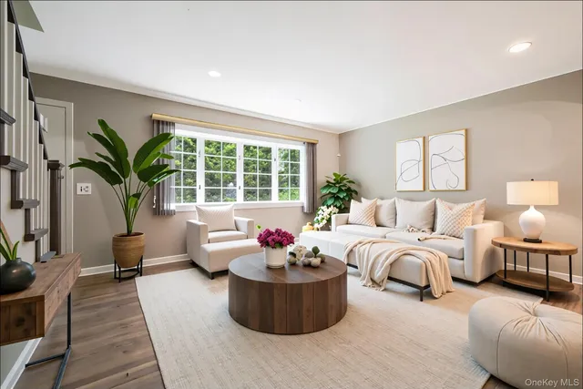 a living room with furniture and a large window with garden view