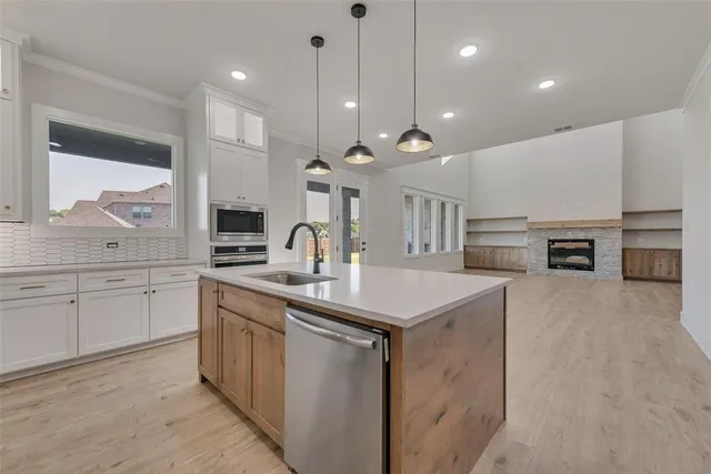 a open kitchen with stainless steel appliances granite countertop a sink a stove and a refrigerator