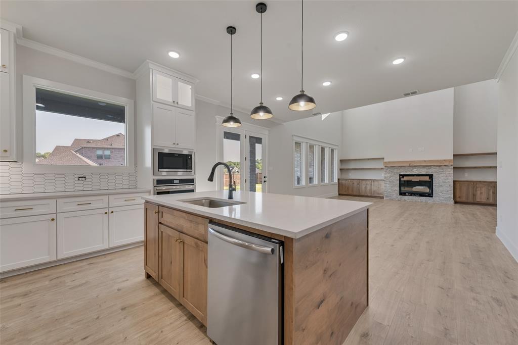 1342 Benjamin Trail Van Alstyne, TX 75495 - Photo 12 of 39 a open kitchen with stainless steel appliances granite countertop a sink a stove and a refrigerator