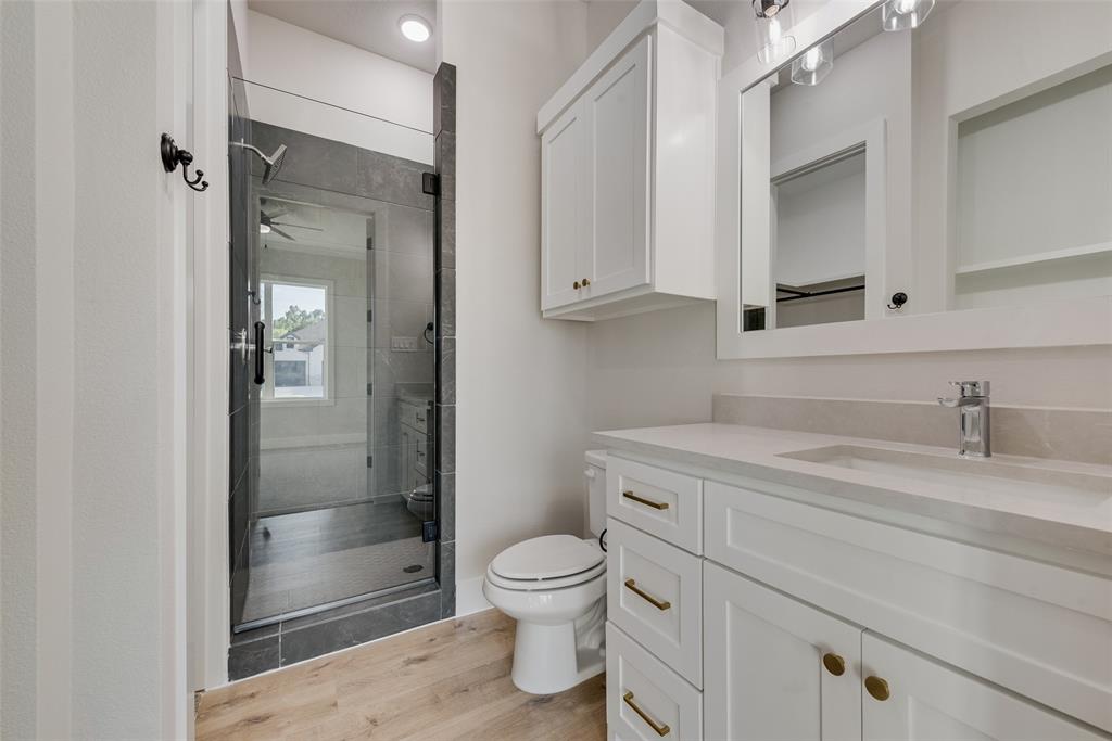 1342 Benjamin Trail Van Alstyne, TX 75495 - Photo 19 of 39 a bathroom with a granite countertop sink a toilet and shower