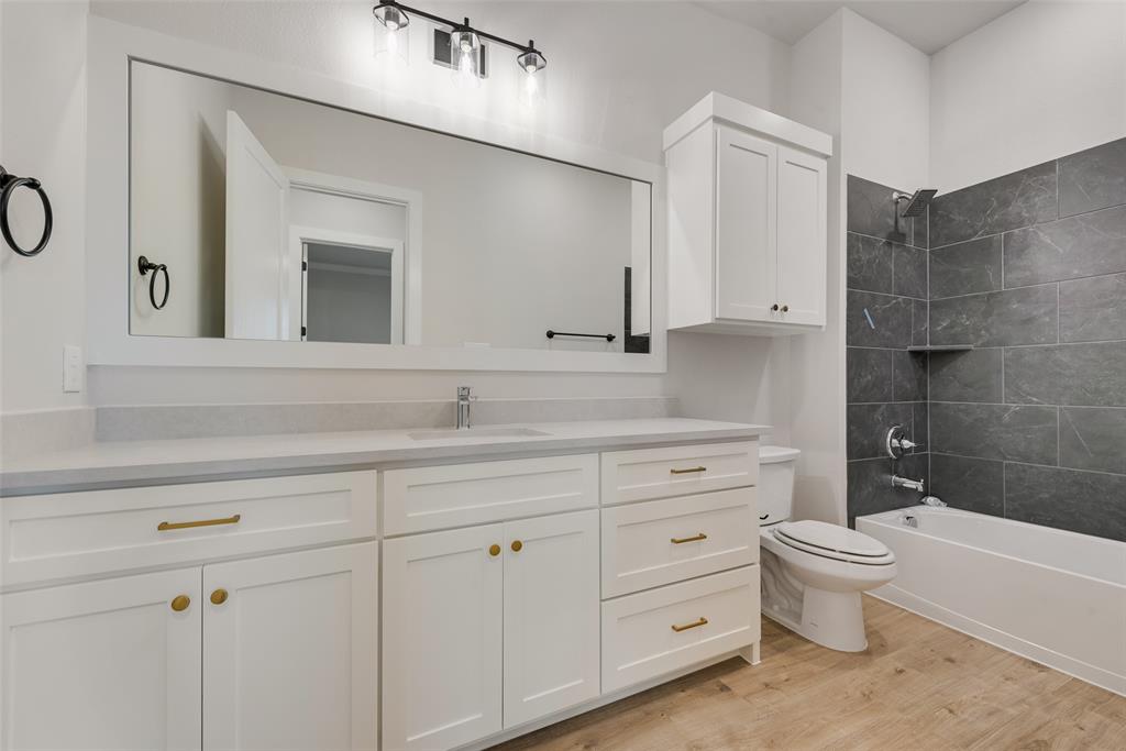1342 Benjamin Trail Van Alstyne, TX 75495 - Photo 31 of 39 a bathroom with a double vanity sink a toilet and a mirror
