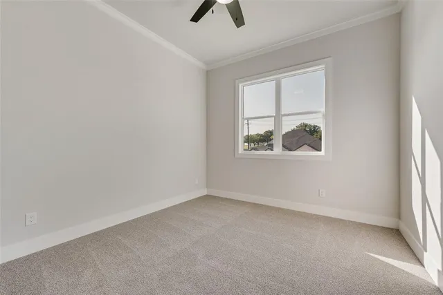 an empty room with windows and ceiling fan