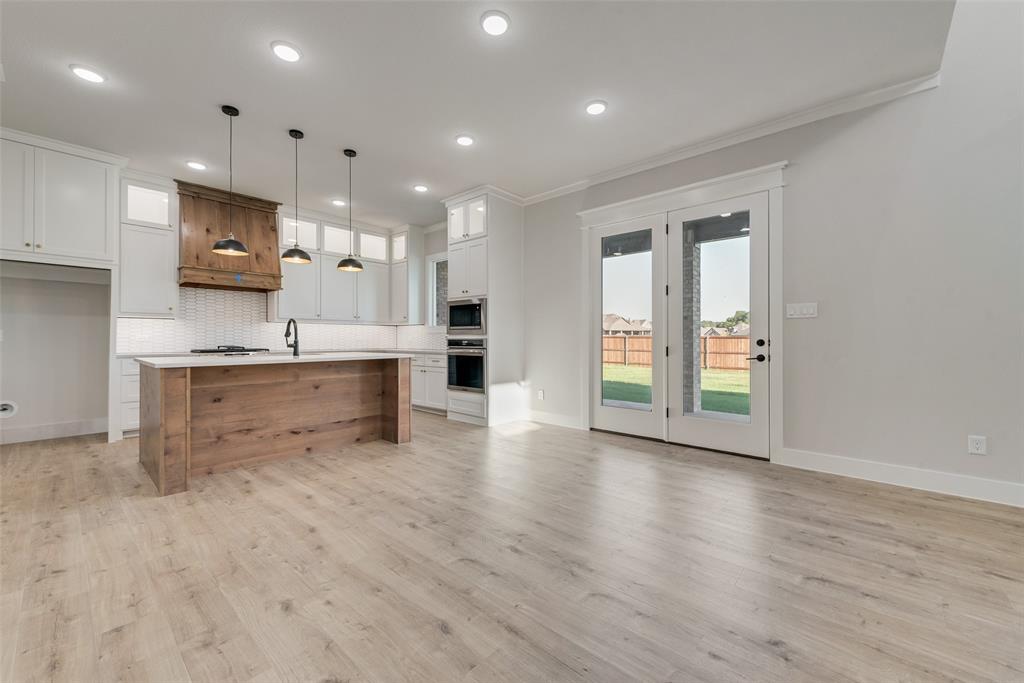 1342 Benjamin Trail Van Alstyne, TX 75495 - Photo 6 of 39 a view of kitchen with stainless steel appliances granite countertop a stove top oven a sink dishwasher and a refrigerator with wooden floor