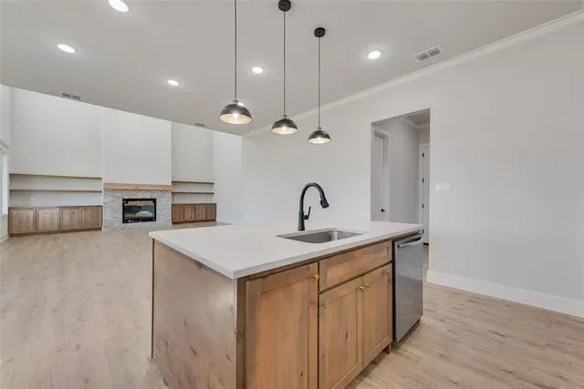 a kitchen with kitchen island a sink appliances and a counter top space