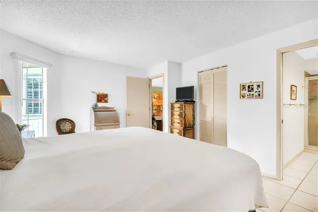 a large bedroom with a bed and a large mirror in it