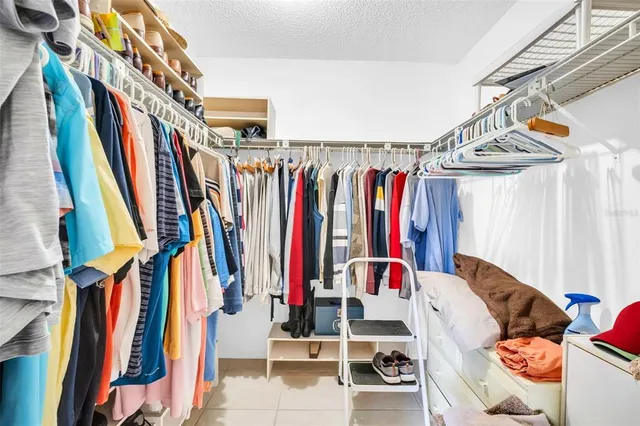 a view of walk in closet with clothes and shoes