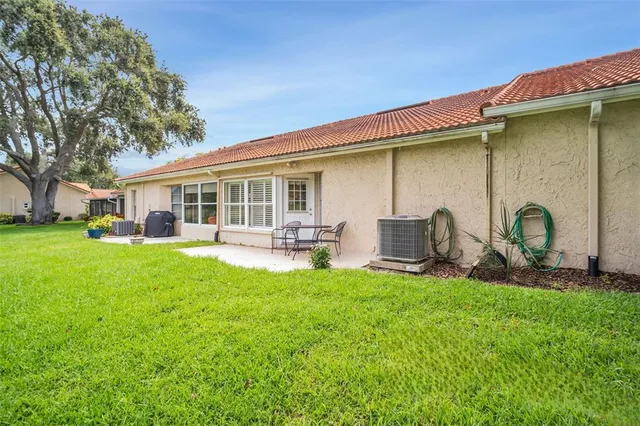 a backyard of a house with table and chairs