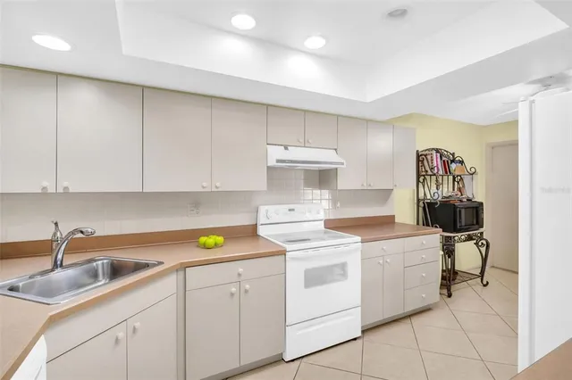 a kitchen that has a sink cabinets counter space and appliances