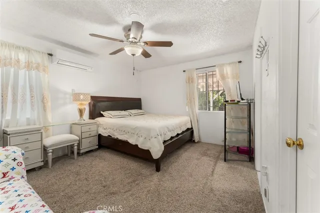 a spacious bedroom with a bed and a flat tv screen