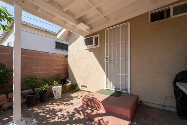 a patio with table and chairs and potted plants