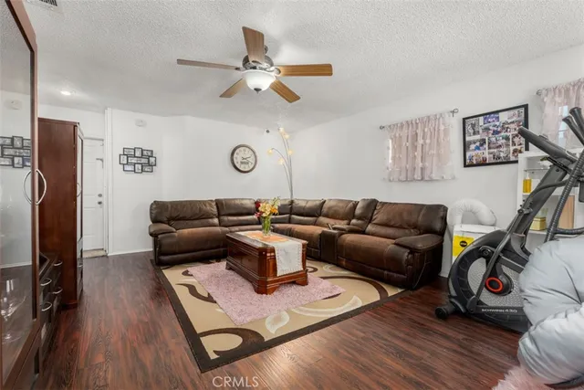 a living room with furniture a flat screen tv and a wooden floor