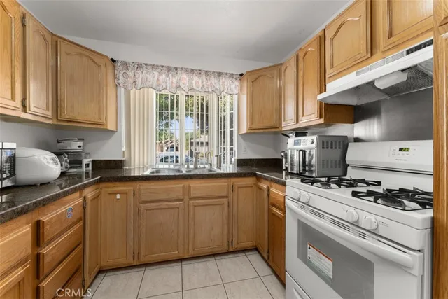 a kitchen with cabinets appliances a sink and a window