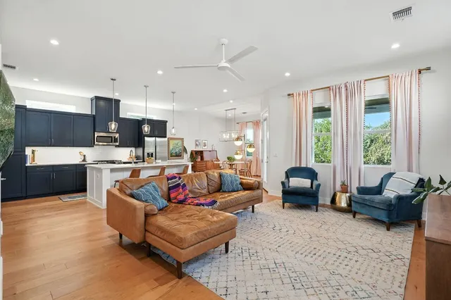 a living room with furniture kitchen and a large window