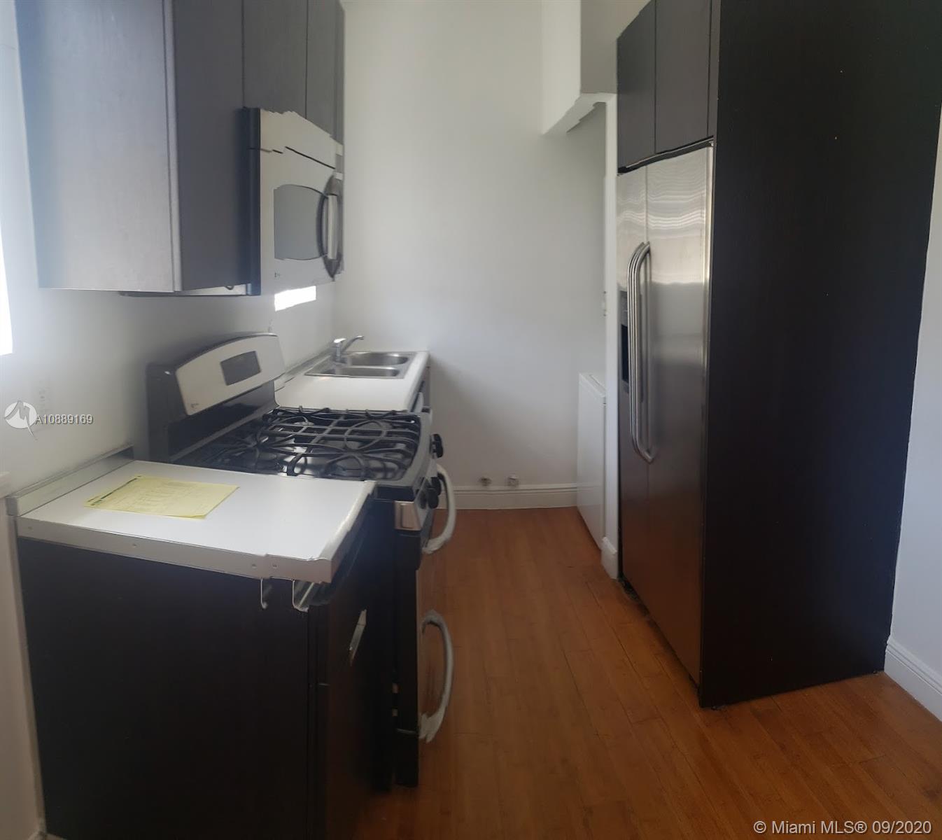 4812 Pine Tree Drive, Unit 203 Miami Beach, FL 33140 - Photo 4 of 19 a kitchen with a refrigerator and a stove top oven