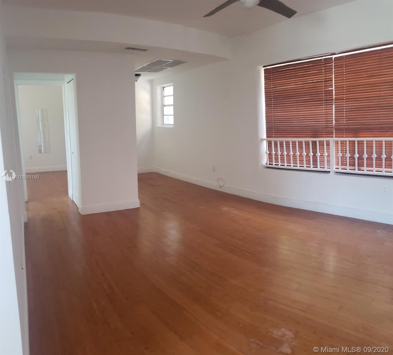 4812 Pine Tree Drive, Unit 203 Miami Beach, FL 33140 - Photo 6 of 19 an empty room with wooden floor and windows