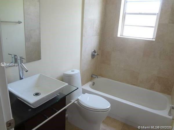 4812 Pine Tree Drive, Unit 203 Miami Beach, FL 33140 - Photo 9 of 19 a bathroom with a sink a toilet and bathtub
