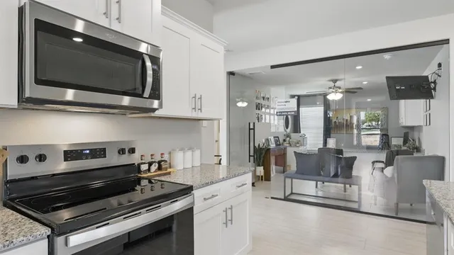 a kitchen with kitchen island granite countertop a sink cabinets and stainless steel appliances