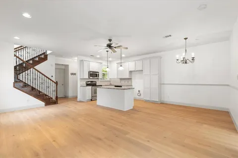 a view of a kitchen with kitchen island stainless steel appliances counter space and a chandelier