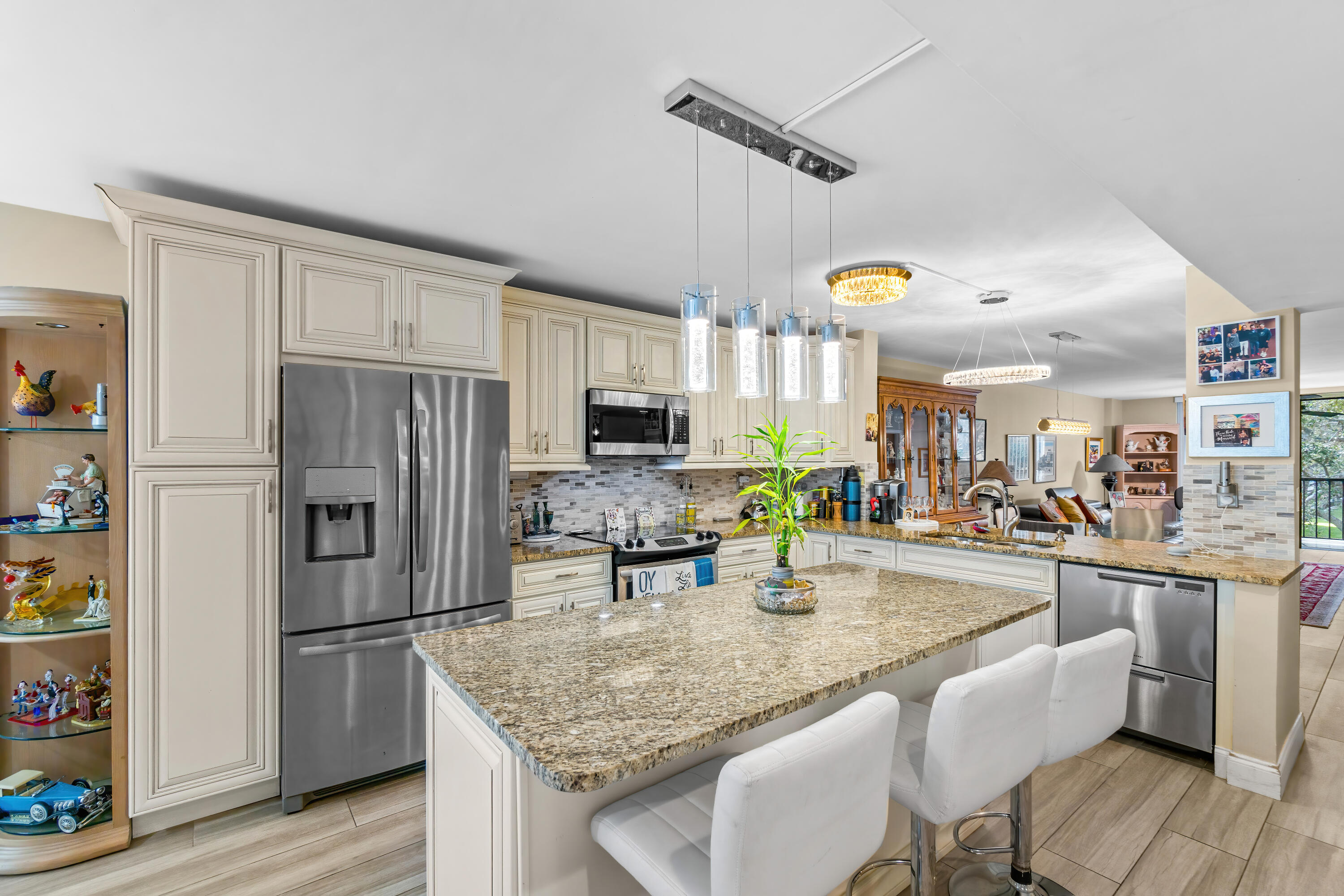 a kitchen with stainless steel appliances granite countertop a sink a refrigerator and a refrigerator