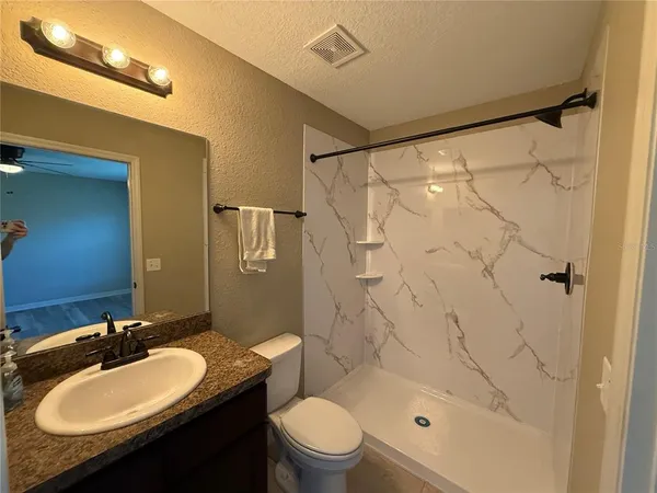 a bathroom with a sink a toilet and shower