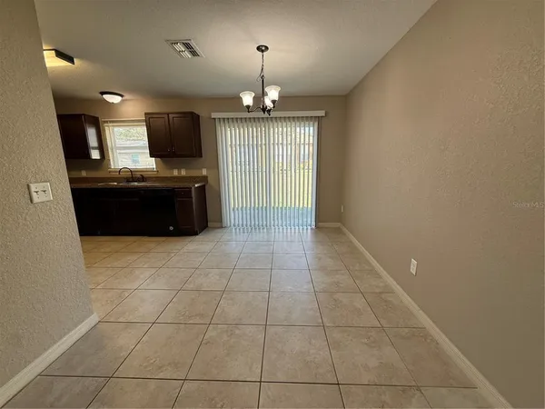 a large kitchen with granite countertop a stove top oven a sink a counter space and cabinets