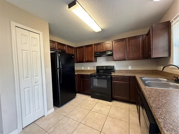 a kitchen with granite countertop a refrigerator and a sink