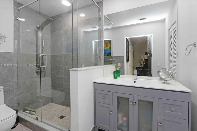 a bathroom with a shower sink and mirror