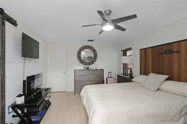 a bedroom with a bed a clock on the wall and dresser