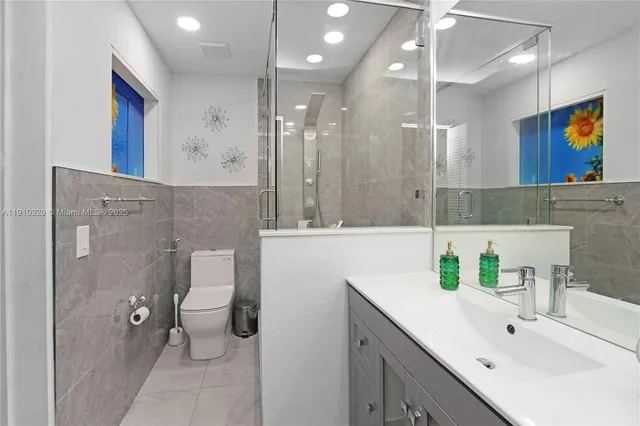 a bathroom with a sink a toilet and a large mirror