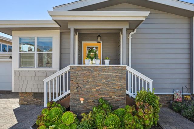 a view of a house with brick walls and flower plants