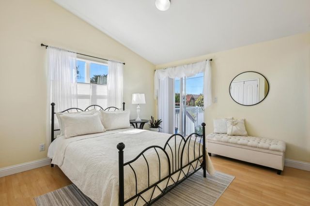 a bedroom with a large bed and wooden floor