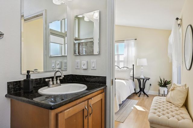a bathroom with a granite countertop sink and a mirror