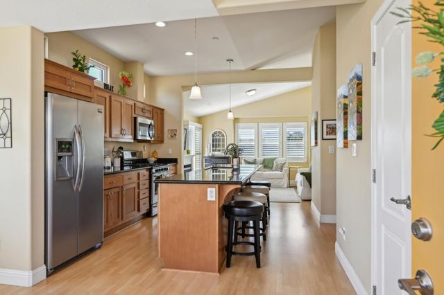 a kitchen with stainless steel appliances a refrigerator a stove top oven a dining table and chairs