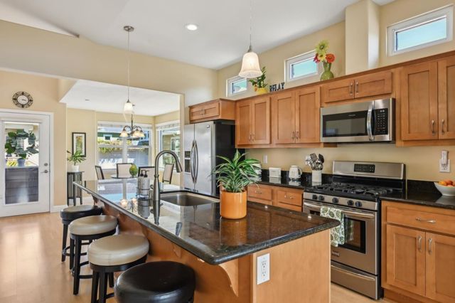 a kitchen with stainless steel appliances kitchen island granite countertop a sink and cabinets