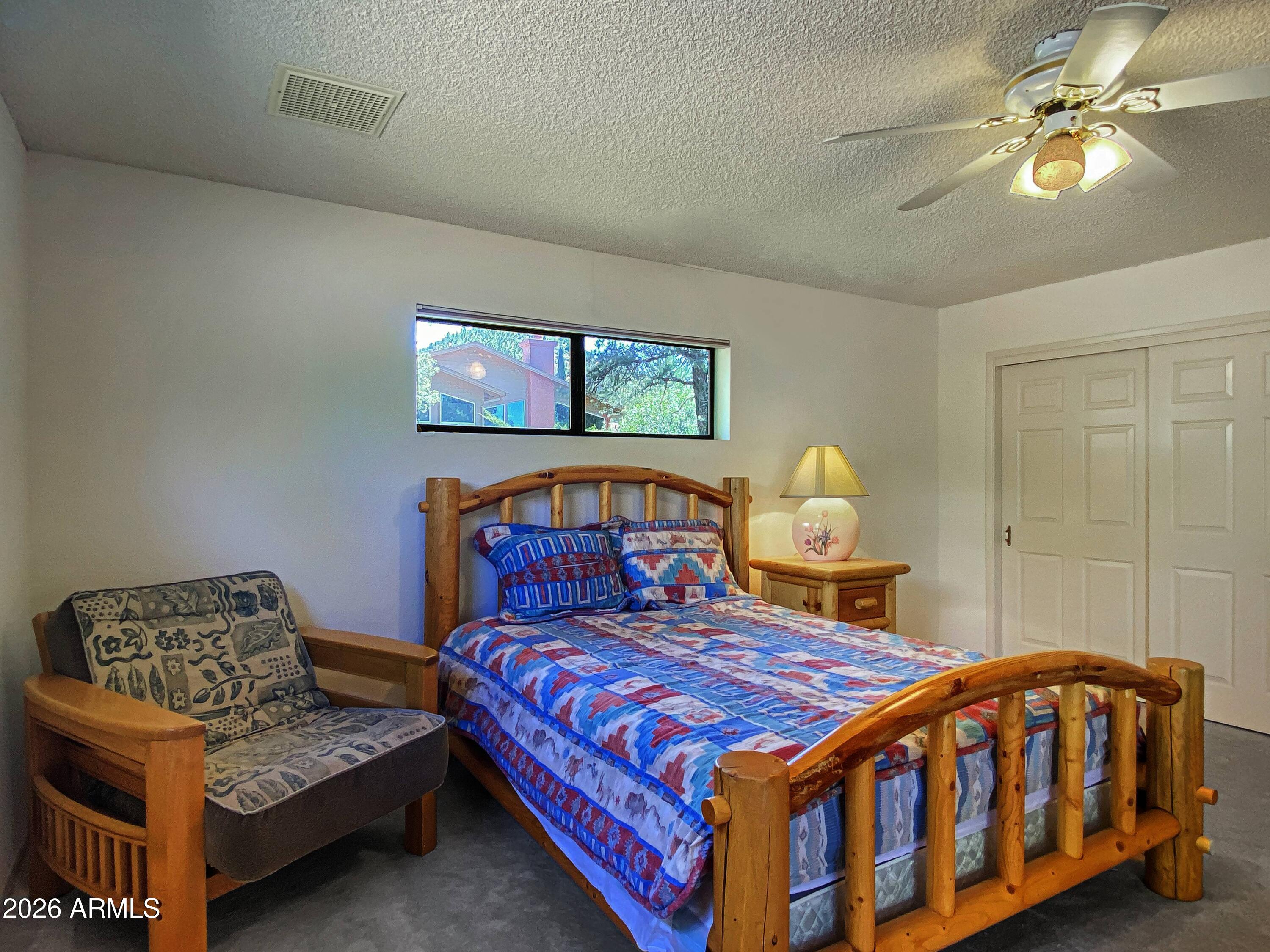 550 Barcelona Road Sedona, AZ 86336 - Photo 18 of 32 a bedroom with a bed and a chandelier