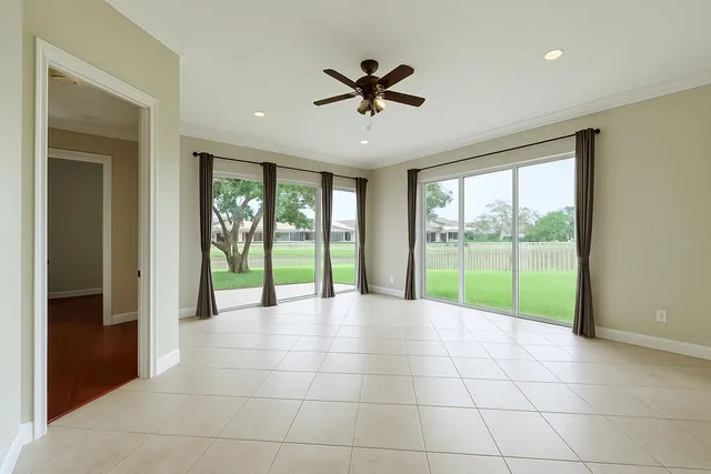 a view of an empty room with a floor to ceiling window and a ceiling fan