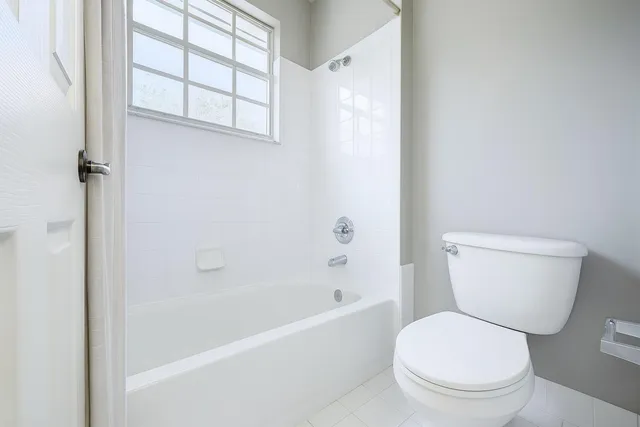 a white toilet sitting next to a bath tub