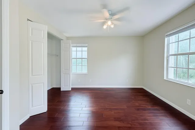 an empty room with wooden floor and windows