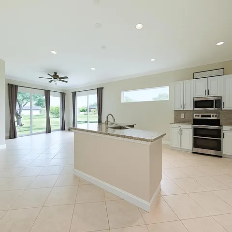a large white kitchen with wooden cabinets and a stove
