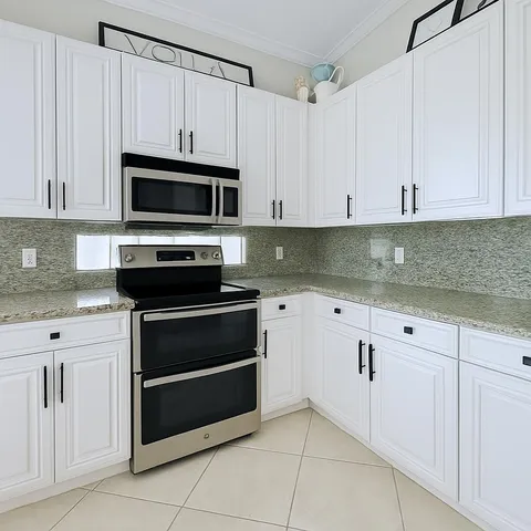 a kitchen with white cabinets and stainless steel appliances