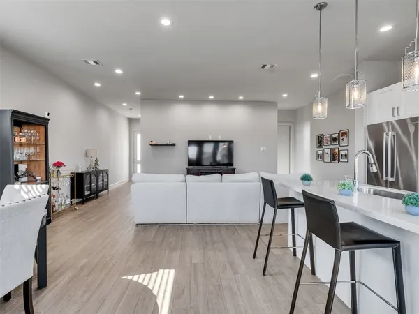 a kitchen with stainless steel appliances granite countertop a sink a stove a refrigerator and island with wooden floor