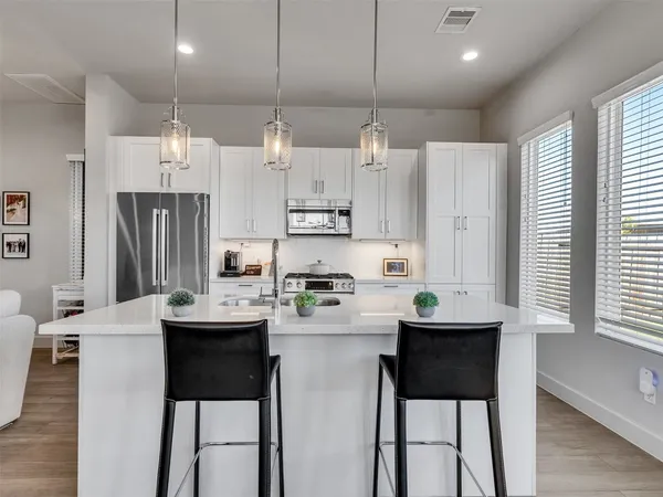 a kitchen with a sink a counter top space and stainless steel appliances