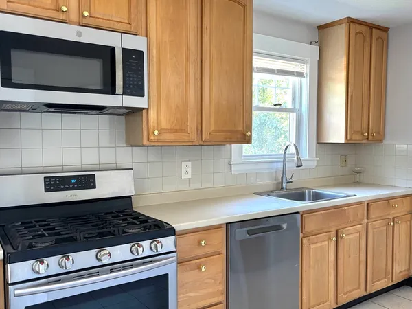 a kitchen with stainless steel appliances granite countertop a sink stove and microwave