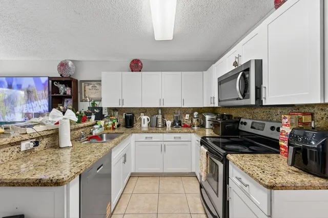 a kitchen with stainless steel appliances granite countertop a sink stove and cabinets