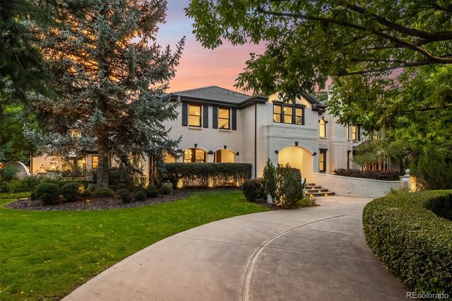 a view of a swimming pool with lawn chairs under an umbrella
