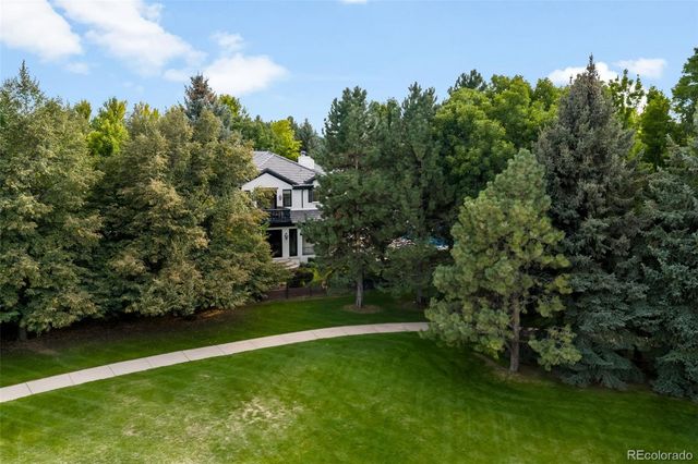 an aerial view of residential house with outdoor space and trees all around