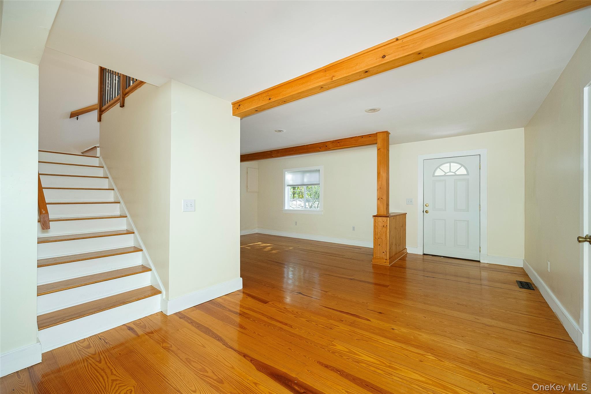 2 Haggerty Hill Road Rhinebeck, NY 12572 - Photo 10 of 47 Unfurnished living room featuring stairway, light wood-type flooring, and beam ceiling