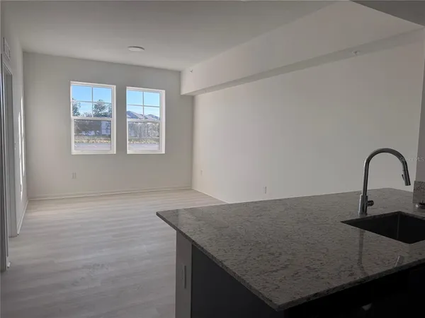 a kitchen with granite countertop a sink a stove and cabinets